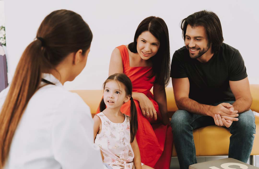 Pediatrician Talks To Little Girl In Office